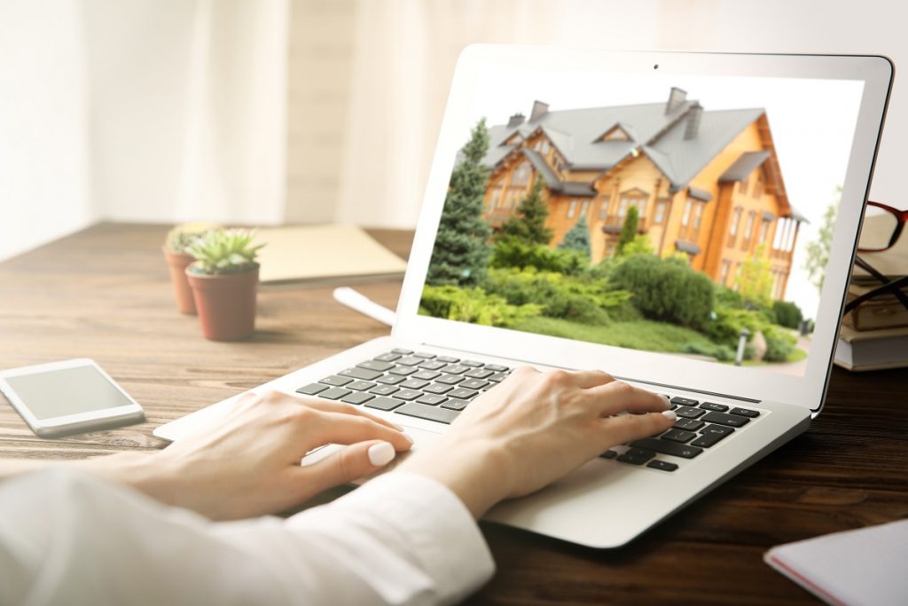 Woman looking at house on laptop