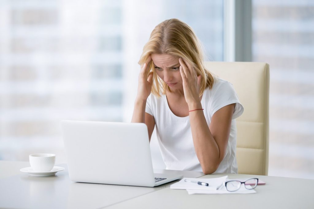Stressed employee looking at her laptop