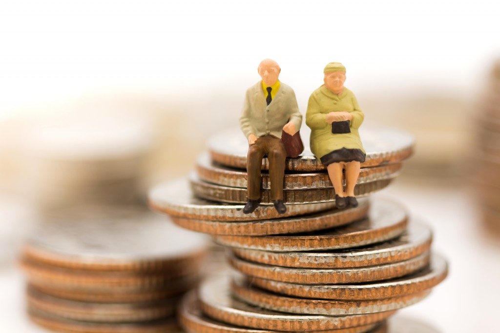 two figures of seniors sitting on coins
