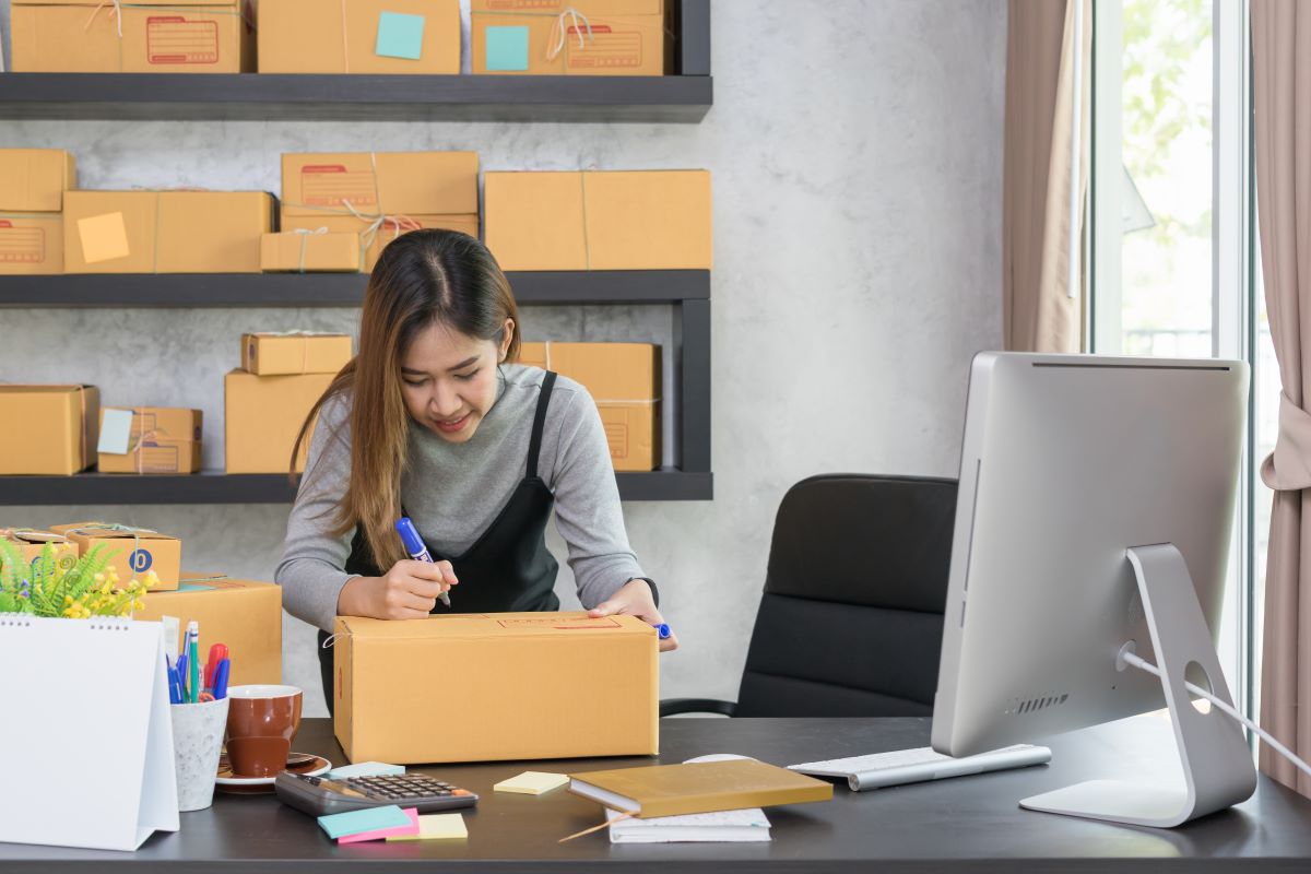 woman writing on a box to deliver