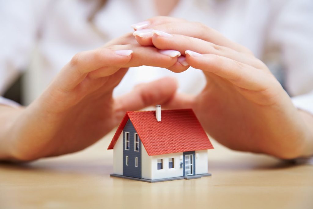 hand hovering over miniature house