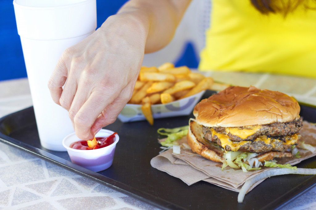 woman dipping fries into ketchup