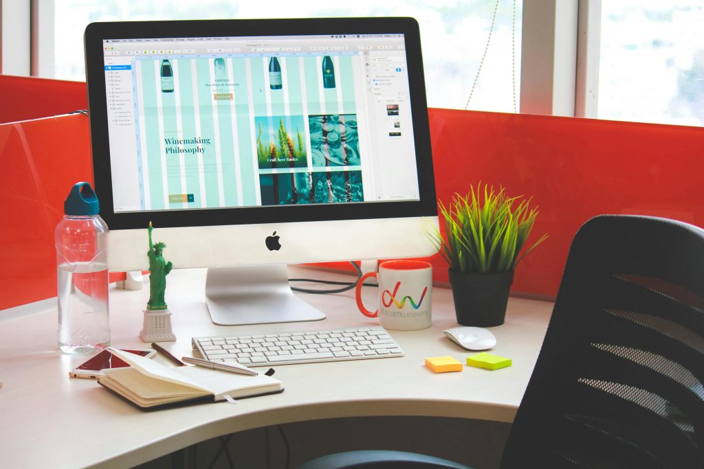 website open on a desktop computer screen, with stylish desk decor