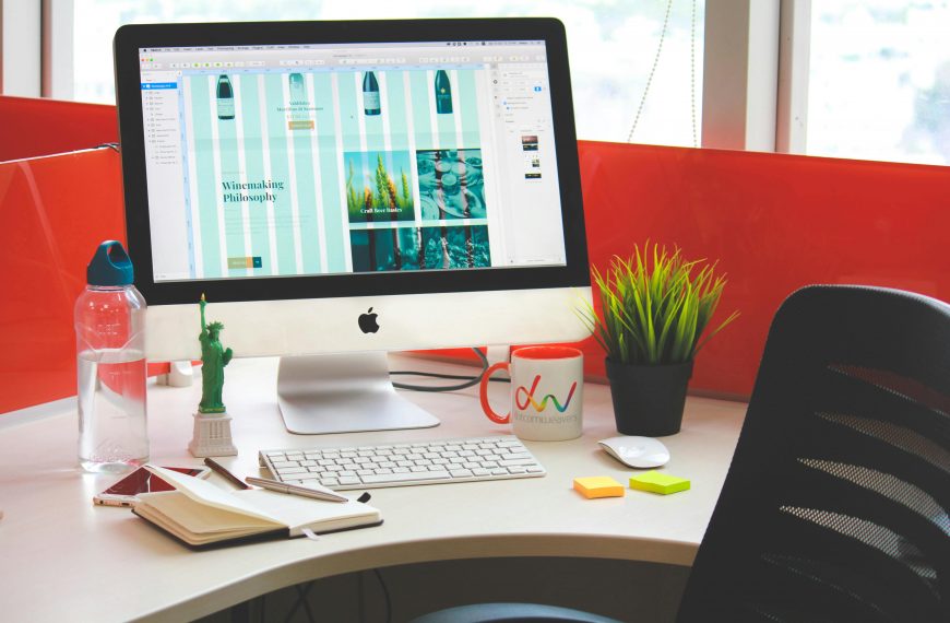 website open on a desktop computer screen, with stylish desk decor