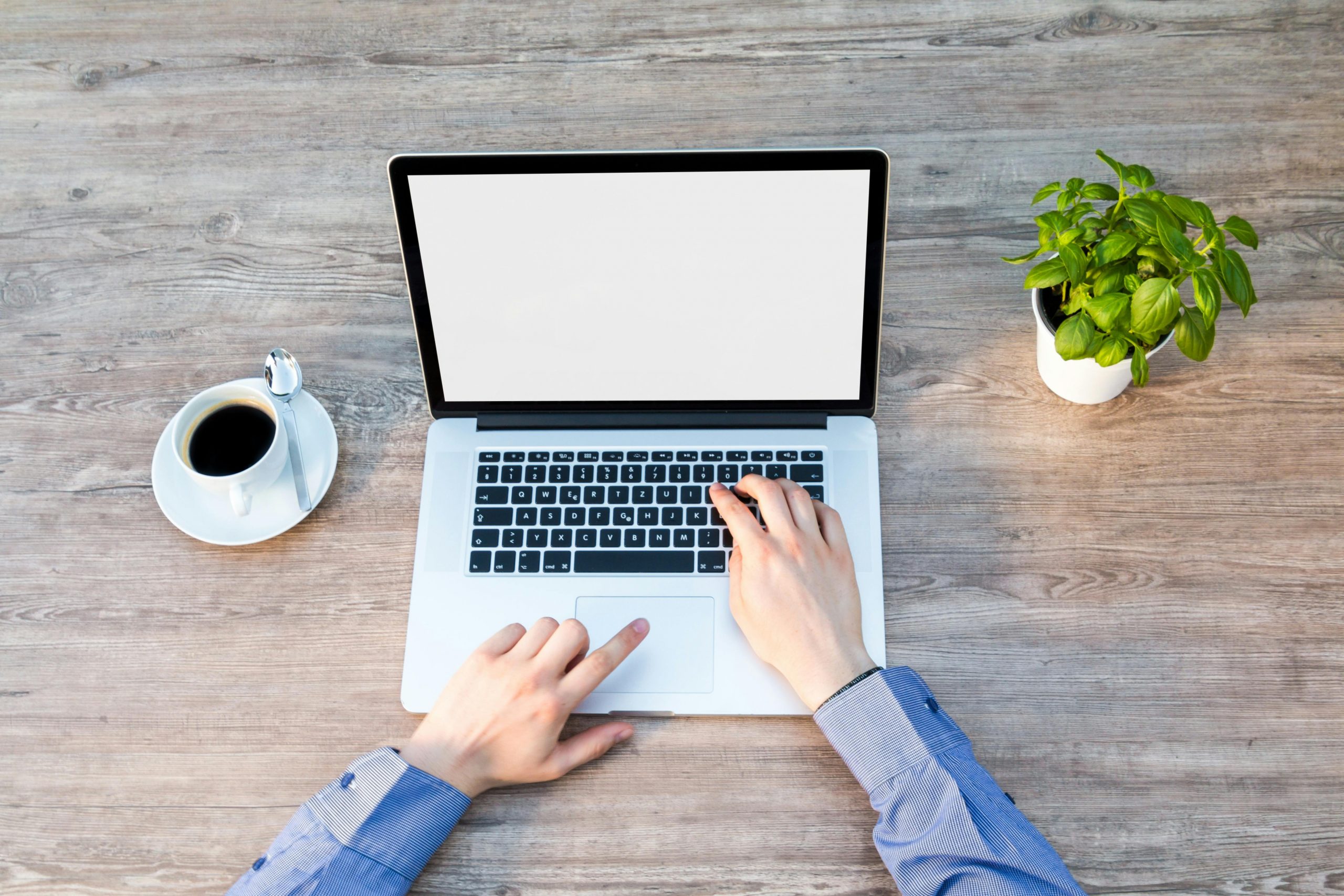person using a laptop with one hand typing and the other on the touchpad